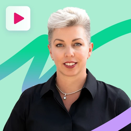 A woman with short, light-colored hair and a black collared shirt smiles slightly at the camera, wearing a silver chain with a heart pendant, against a mint green and purple abstract background with a play button icon.
